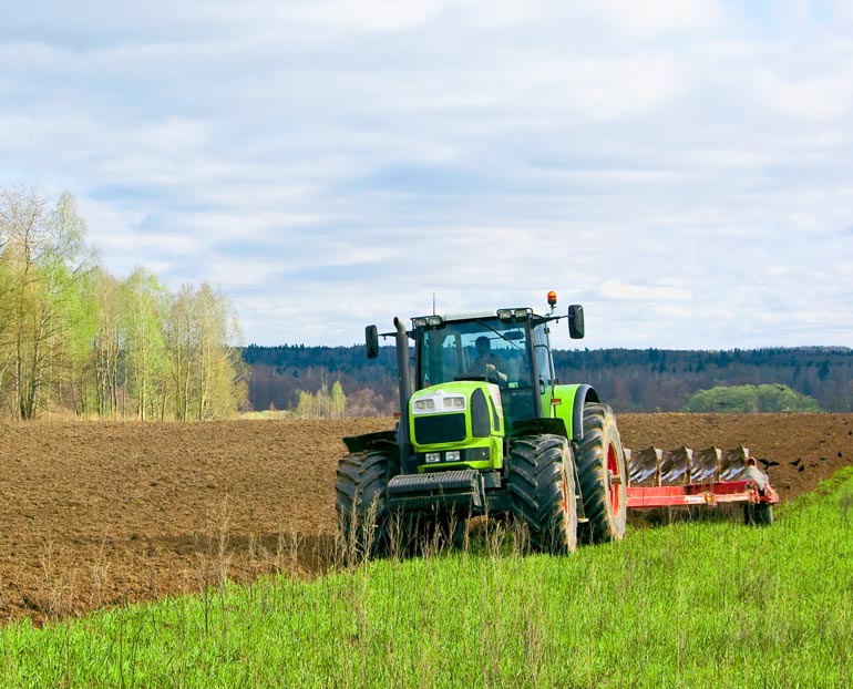 Farmer in tractor plowing his field